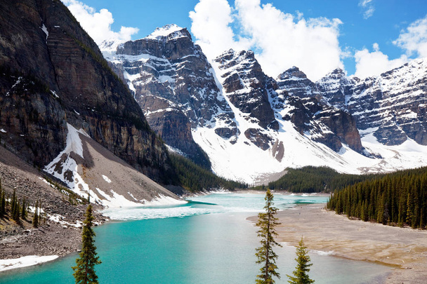 Wunderschönes türkisfarbenes Wasser des Moränensees mit schneebedeckten Gipfeln darüber im Banff National Park in Kanada - Foto, Bild
