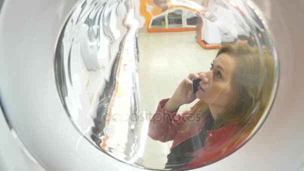 A woman buys a washing machine in a store, 4k, slow-motion - Materiał filmowy, wideo