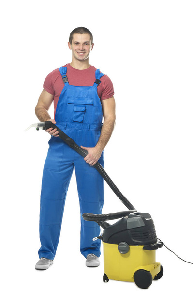 Young man with vacuum cleaner - Φωτογραφία, εικόνα