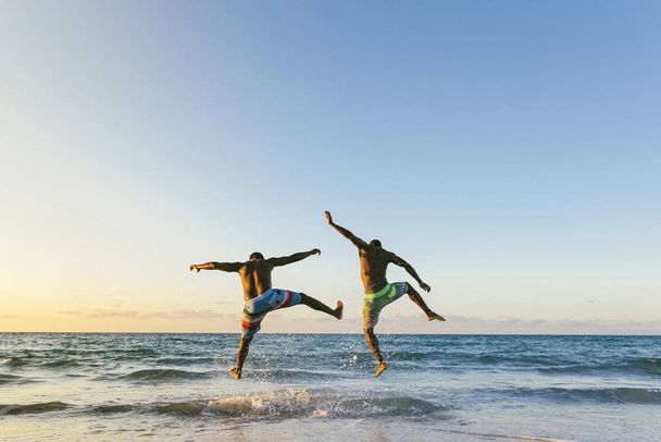 Two cuban friends having fun in the beach.  - 写真・画像