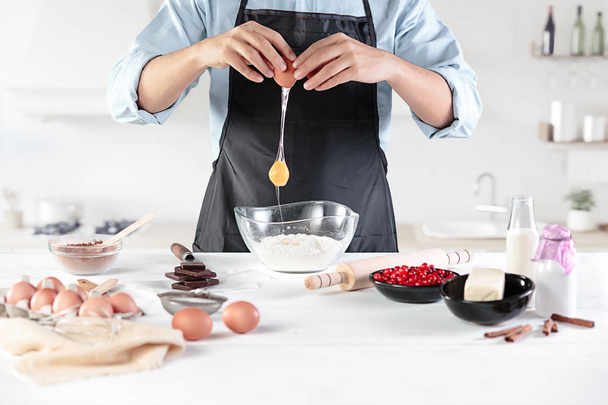 A cook with eggs on a rustic kitchen against the background of mens hands - Foto, Bild