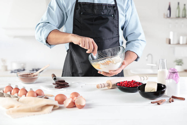 A cook with eggs on a rustic kitchen against the background of mens hands - Photo, Image