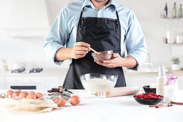 A cook with eggs on a rustic kitchen against the background of mens hands - Photo, image