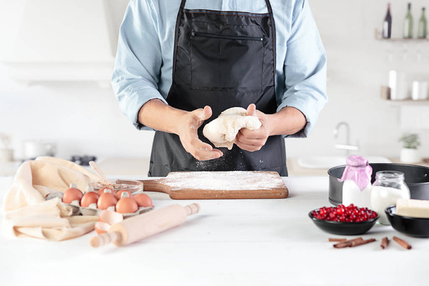 A cook with eggs on a rustic kitchen against the background of mens hands - Foto, immagini