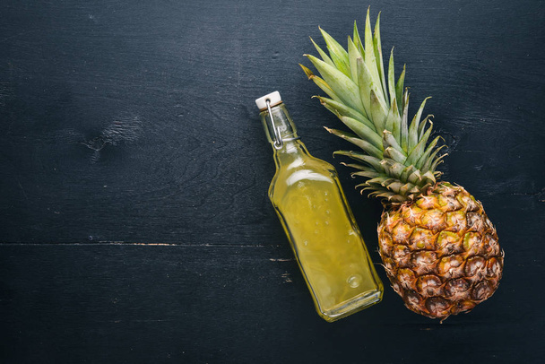 Fresh pineapple and pineapple juice. On a wooden background. Top view. Free space for text. - Valokuva, kuva