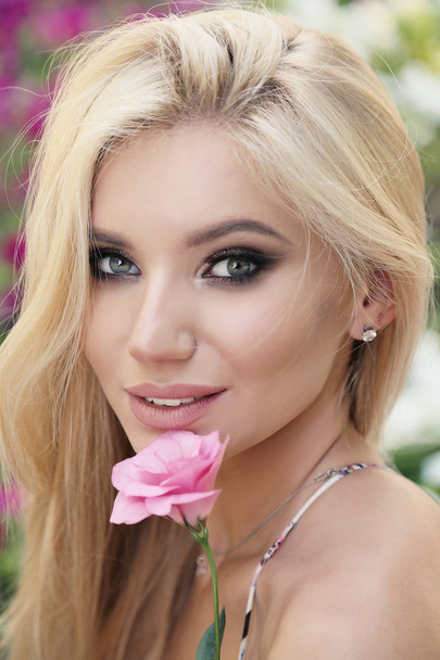 beautiful girl with blond hair posing with flower - Zdjęcie, obraz