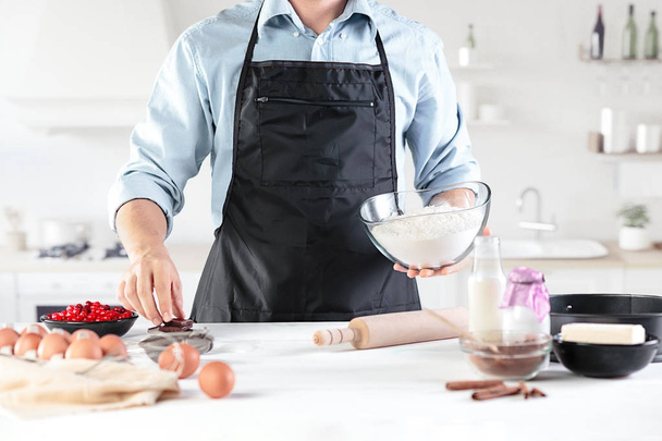 A cook with eggs on a rustic kitchen against the background of mens hands - Foto, afbeelding