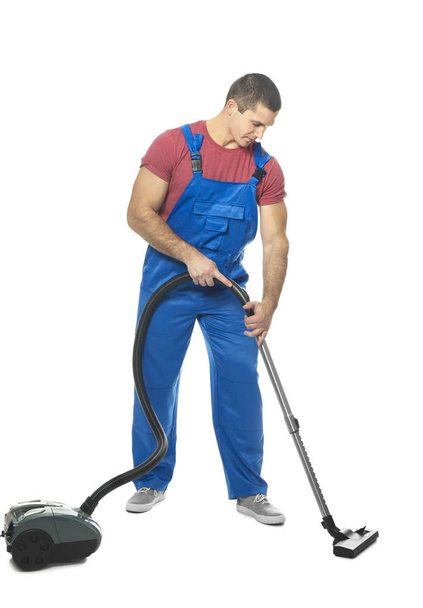 Young man with vacuum cleaner - 写真・画像