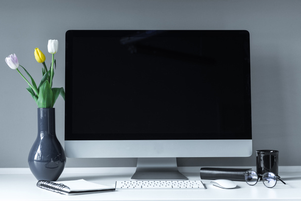 Vase mit Tulpen auf weißem Arbeitstisch - Foto, Bild