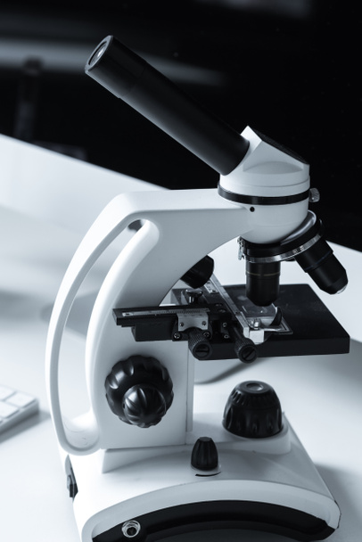 λευκό και μαύρο μικροσκόπιο στο τραπέζι εργασίας - Φωτογραφία, εικόνα