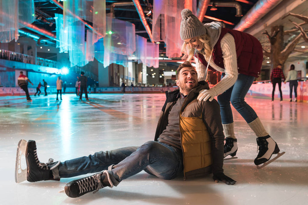 beautiful smiling young couple teaching ice skating on rink - Photo, Image