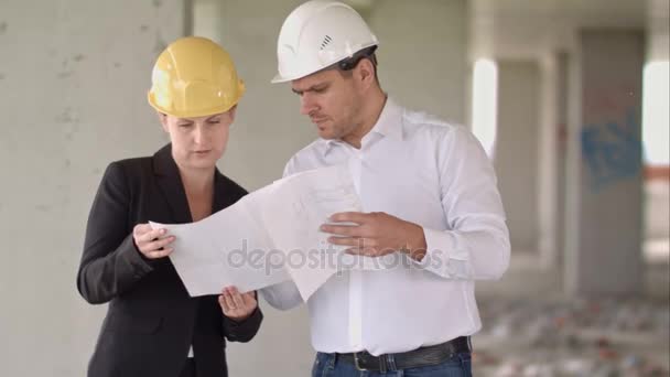 Arquitecto equipo hombre y mujer discutiendo sobre el plan de construcción para la construcción en el sitio de trabajo
 - Imágenes, Vídeo