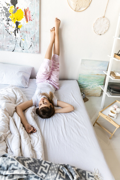 fiatal nő pizsamában pihen, ágyban reggel otthon - Fotó, kép