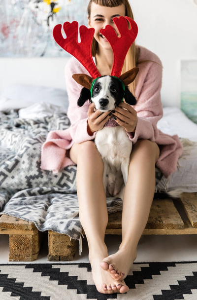 selective focus of smiling woman and cute little puppy with deer horns on head - Photo, Image