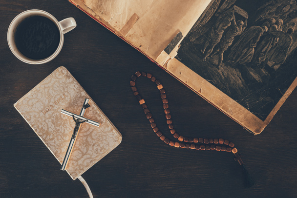 szemközti nézet nyitott Biblia és a rózsafüzér a fából készült asztal - Fotó, kép