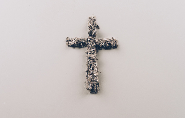 Ansicht der Kreuzform aus Asche auf weißer Oberfläche - Foto, Bild