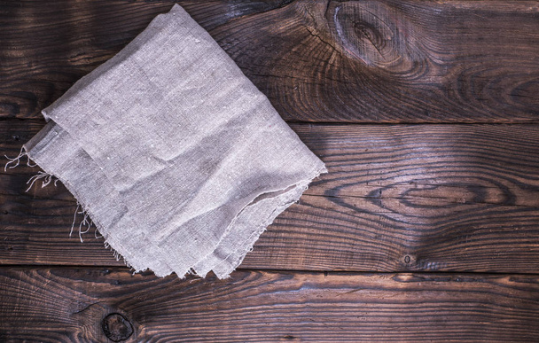 gray linen napkin on a brown wooden background - Photo, Image
