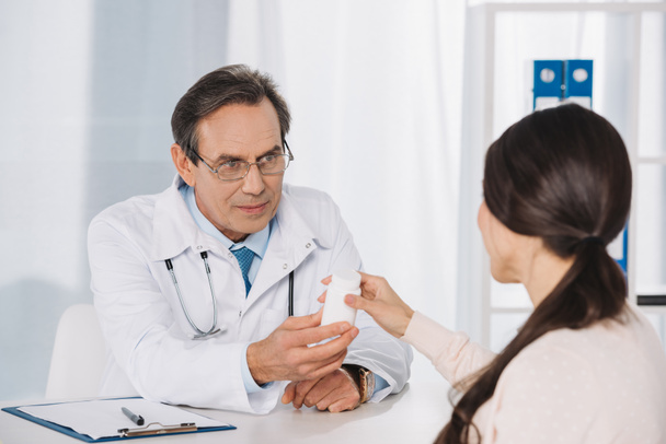 médico masculino dando píldoras a paciente femenino
 - Foto, Imagen