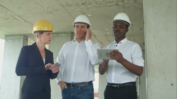Исполнительная команда на строительной площадке просмотр с планшетом, смартфоном, формально одетые люди, читающие строительный планшет
 - Кадры, видео