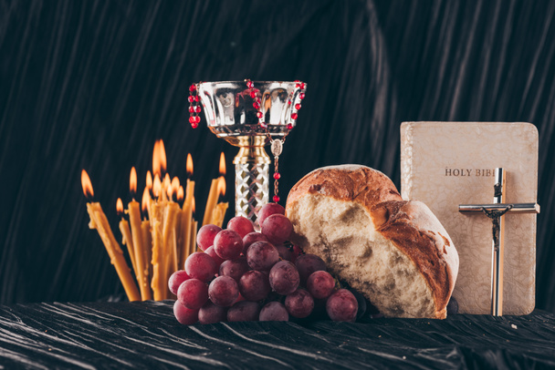malja, pyhä raamattu, kristillinen risti, kynttilät ja ruoka pyhään ehtoolliseen
 - Valokuva, kuva