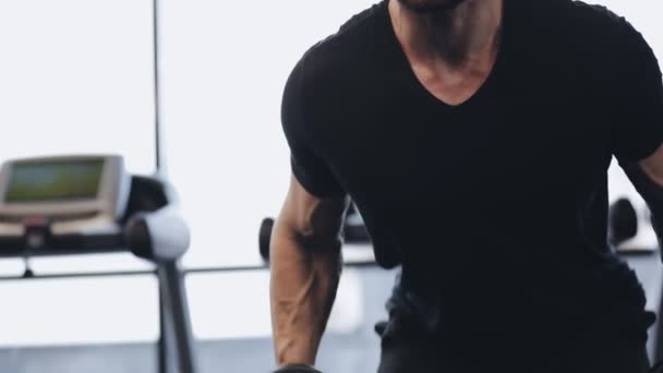 Man working with dumbbell in gym, he pumping muscles - Video, Çekim