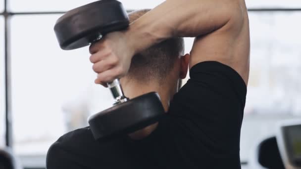 Man working with dumbbell in gym, he pumping muscles - Metraje, vídeo