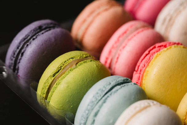 Colorful macaroons set on black background. Closeup food photo - Foto, afbeelding