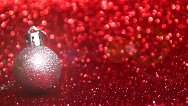 a silver ball with glitter on a red background, place to print your text - Footage, Video