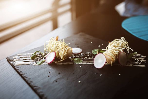 Tiger shrimps in chinese noodles with sauce on black slate plate. Asian concept. Food photo. Flare copyspace - Fotó, kép