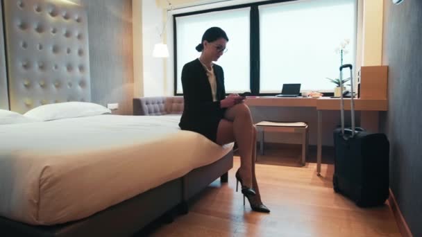 Επαγγελματικά ταξίδια νεαρή γυναίκα επιχειρηματίας με το Smartphone στο δωμάτιο του ξενοδοχείου - Πλάνα, βίντεο