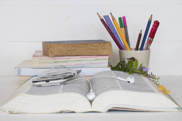 Bildungs-Wörterbuch mit allen Büchern und Schreibwaren zum Lernen auf Tisch weiß - Foto, Bild