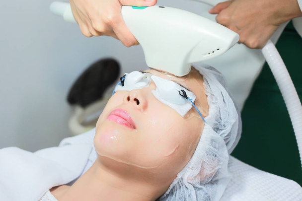 Lähikuva kosmetologi antaa Laser Epilation hoito nuorille
 - Valokuva, kuva