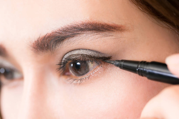 Beautiful woman make-up with black eyeliner. - Photo, Image