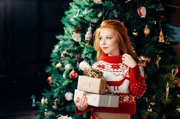 Sexy young woman in sweater is preparing for celebrating New Year at home - Foto, Imagem