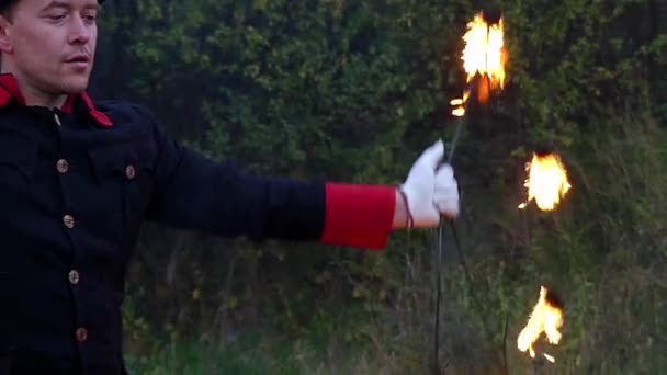 Jongleur dreht im Slo-mo zwei Metallfächer mit Flamme um sich. Es ist Magie - Filmmaterial, Video