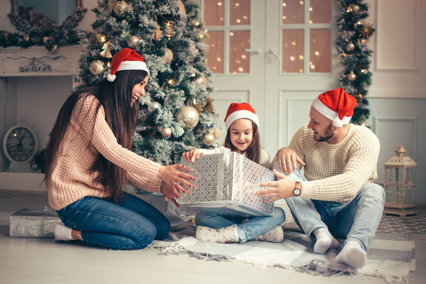 parents with little girl surprised Christmas presents for the New Year - Foto, Bild