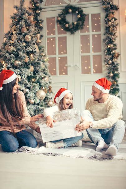 parents with little girl surprised Christmas presents for the New Year - Foto, immagini