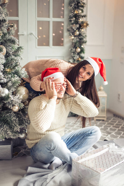 Happy Couple in Santa Hat with Christmas and New Year Gift at Home - Foto, Imagem