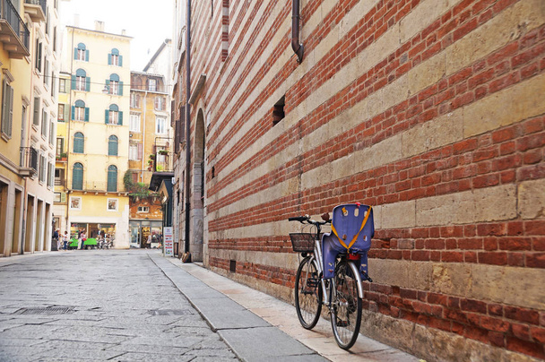 Ruas de Antuérpia. Uma bicicleta com assento de criança está localizada perto da parede na pitoresca e autêntica rua de Antuérpia. Cultura da Bélgica
. - Foto, Imagem