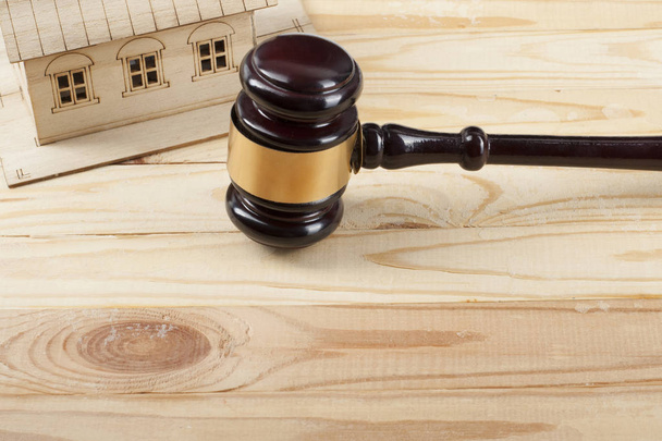 Concept de droit. Maison modèle avec marteau de juge en bois sur la table. Espace de copie pour le texte
 - Photo, image