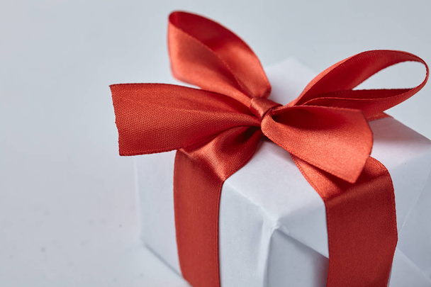 regalo blanco con cinta roja, concepto de vacaciones
  - Foto, imagen