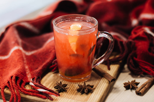 Close-up foto van heerlijke rode hete thee met specerijen en kruiden op tafel - Foto, afbeelding