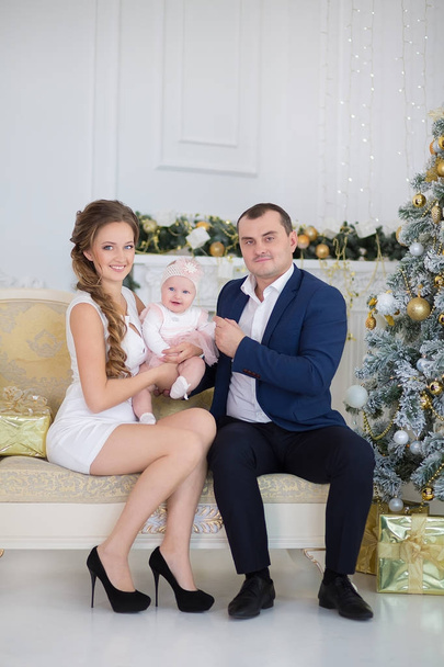 Happy Christmas Family portrait. Smiling Parents with baby daughter at Home Celebrating New Year. Christmas Tree - Foto, Imagen