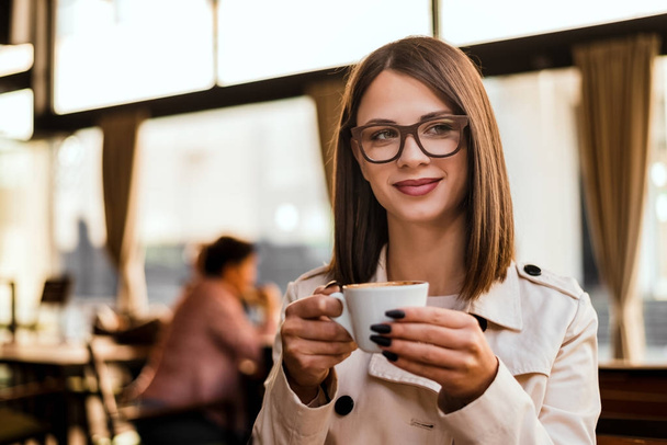  brunette woman holding cup of coffee - Photo, Image