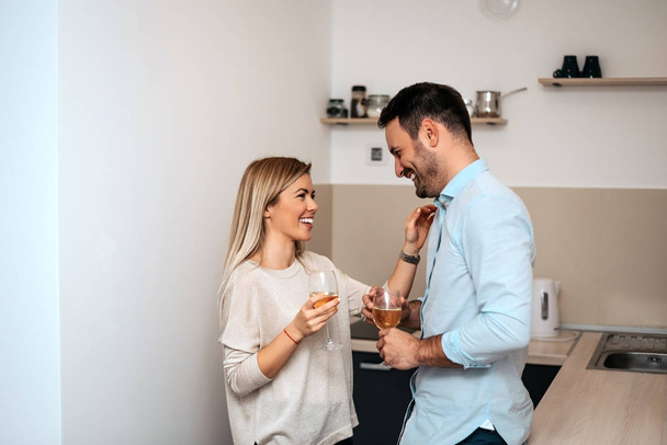 Shot of couple in kitchen drinking wine - Foto, Bild