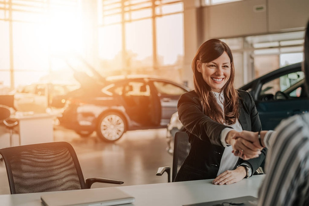 Client shaking hands with car dealer - Фото, изображение