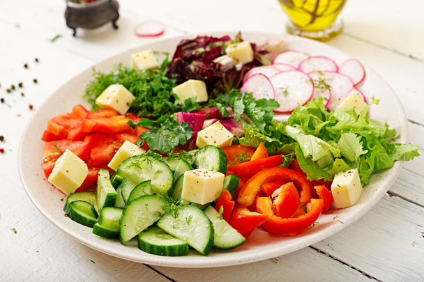 木製テーブルの上の白いボウルで新鮮な野菜とグリーン ハーブ サラダをミックスします。  - 写真・画像