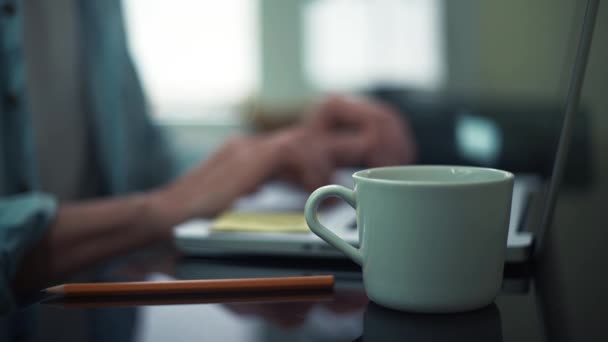 Homme d'affaires utilisant un ordinateur portable au bureau. Tasse à café blanche au bureau. Homme défilant
 - Séquence, vidéo