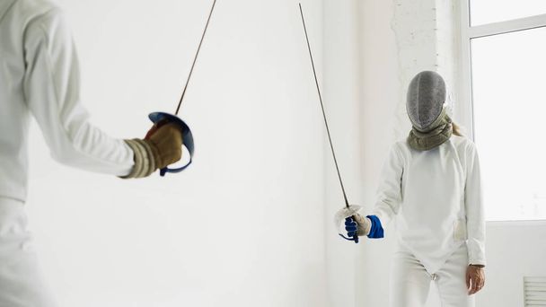 Two fencers having training attack exercises in fencing in studio - Photo, image