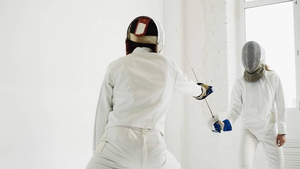 Two fencers having training attack exercises in fencing in studio - Zdjęcie, obraz